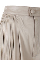 Ivory baggy leather fringe pants by MAZ Manuela Álvarez with flowing fringe details and relaxed fit, shown on a model.
