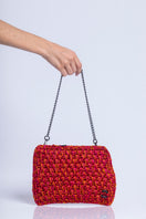 Catarina Mina Brisa clutch bag in vibrant grape-orange color with woven texture and compact design.