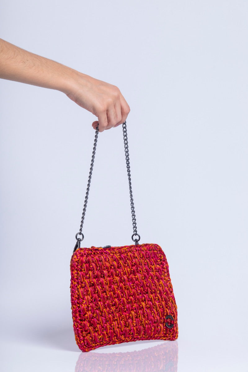 Catarina Mina Brisa clutch bag in vibrant grape orange with a sleek design and textured finish, perfect for evening accessories.