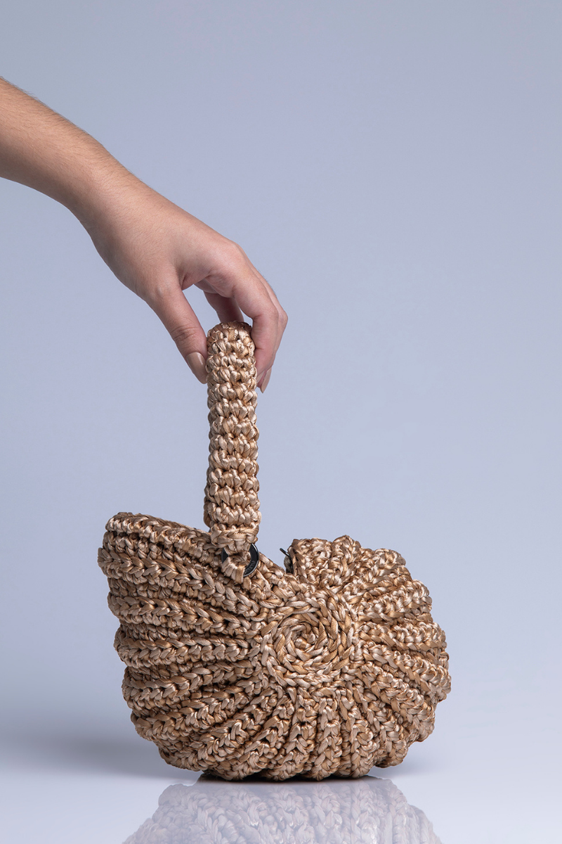 Catarina Mina concha top handle bag in sand color with woven design and sturdy handle, stylish accessory for everyday use.