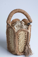 Catarina Mina Lampa sand-colored top handle bag with sleek design and wooden handle, perfect for casual or elegant outings.