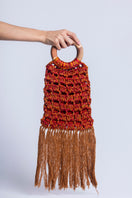 Catarina Mina Vera top handle bag in vibrant grape-orange leather with sleek design and sturdy handles.