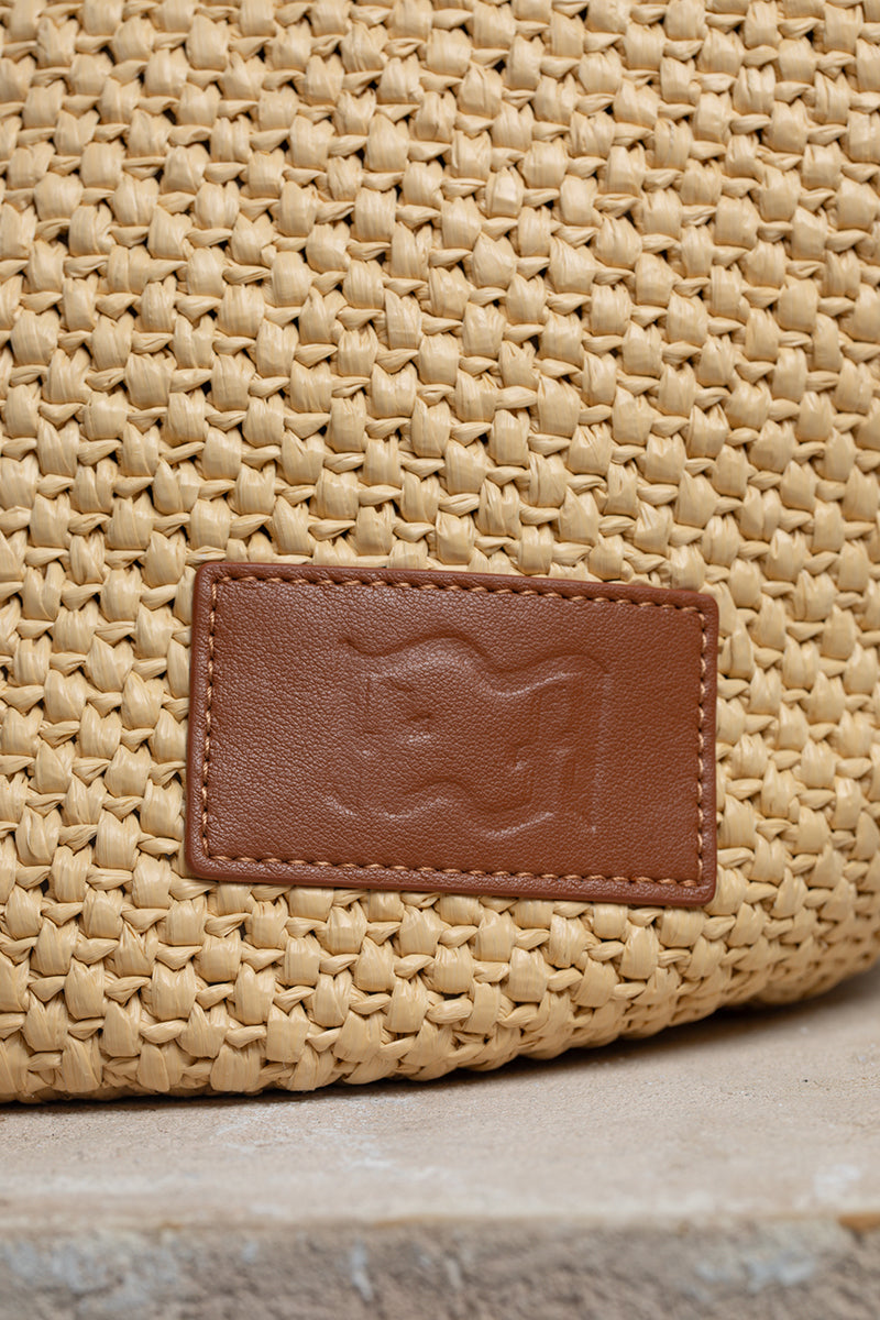 Beige raffia basket bag with top handle from Folklore The Label, perfect for casual and summer outings.