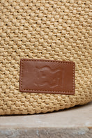 Beige raffia basket bag with top handle from Folklore The Label, perfect for casual and summer outings.