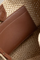Beige raffia basket bag with top handle from Folklore The Label, showcasing woven texture and stylish design.