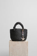 Black raffia basket bag with a top handle from Folklore The Label, featuring a woven basket design and stylish, casual appearance.