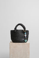 Black raffia basket bag with top handle from Folklore The Label, featuring a woven design and spacious interior.