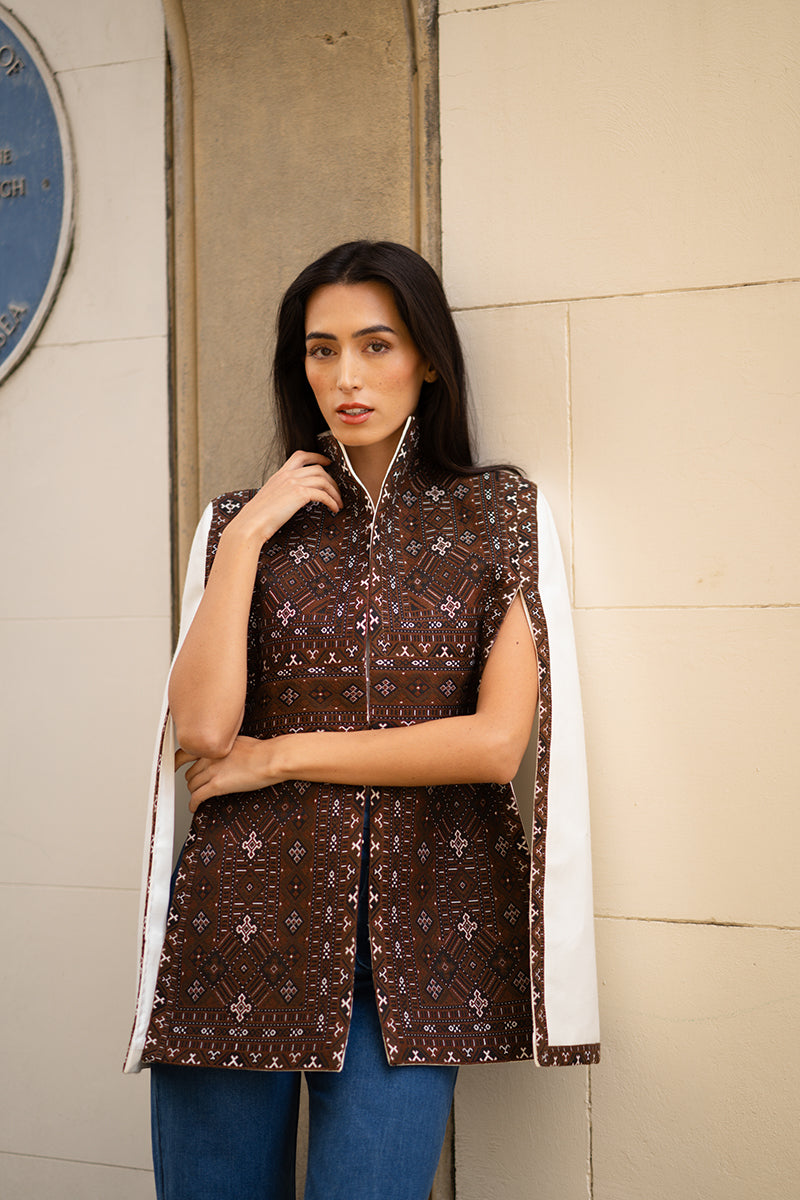 Nadya Shah Balthazar Cape jacket in dark fabric, featuring flowing design and stylish collar detail, displayed on a mannequin.
