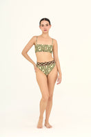 Aguaclara Bedouine high rise bikini bottoms in a vibrant, patterned fabric, styled for a fashionable beach look.