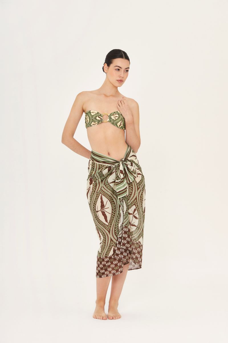 Aguaclara Bedouine Pareo cover-up in lightweight fabric with intricate patterns, draped over a model on a sunny beach.