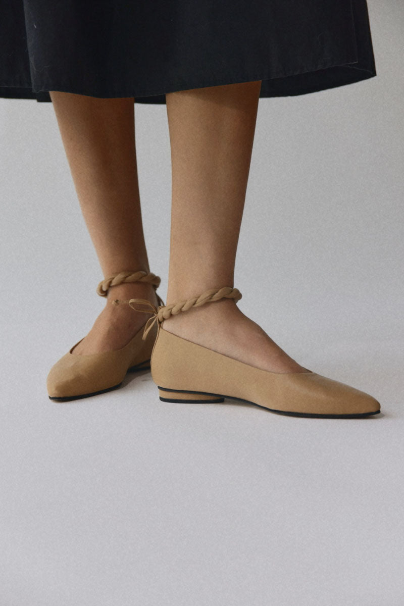 Alta Aria almond flats shown on a background, featuring beige almond-colored slip-on flats with a sleek design.
