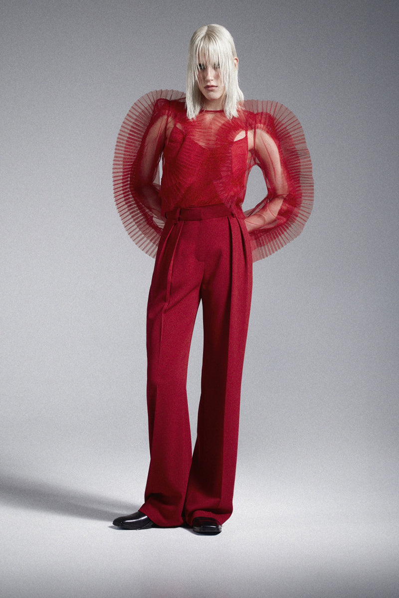 Red translucent tulle blouse with ruffled frills by Nadya Dzyak, featuring delicate sheer fabric and feminine design.
