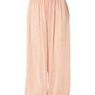 Studio NK Bloom peach pants with a relaxed fit and wide-leg style, shown on a model in a casual outdoor setting.