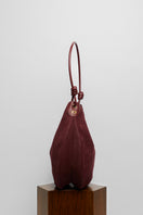Maroon suede boho shoulder bag by Folklore The Label with fringe detailing and adjustable strap.