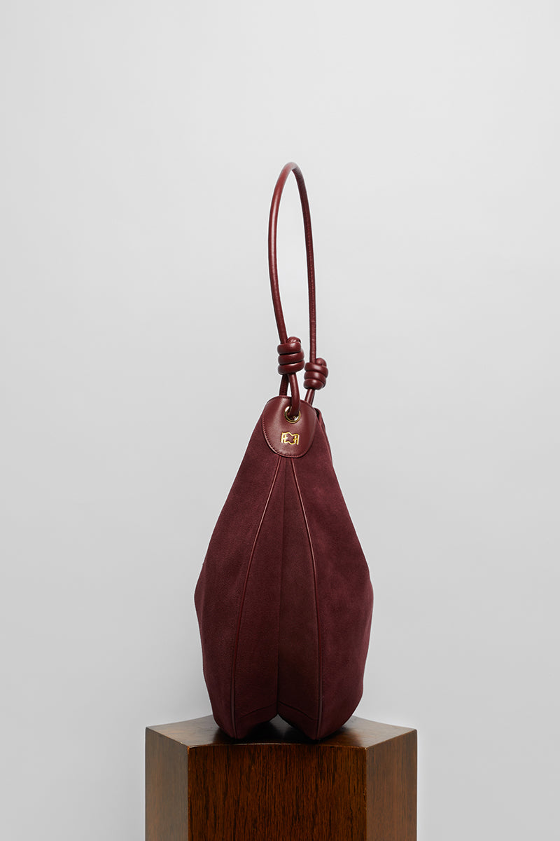 Maroon suede boho shoulder bag by Folklore The Label with fringe detailing and adjustable strap.
