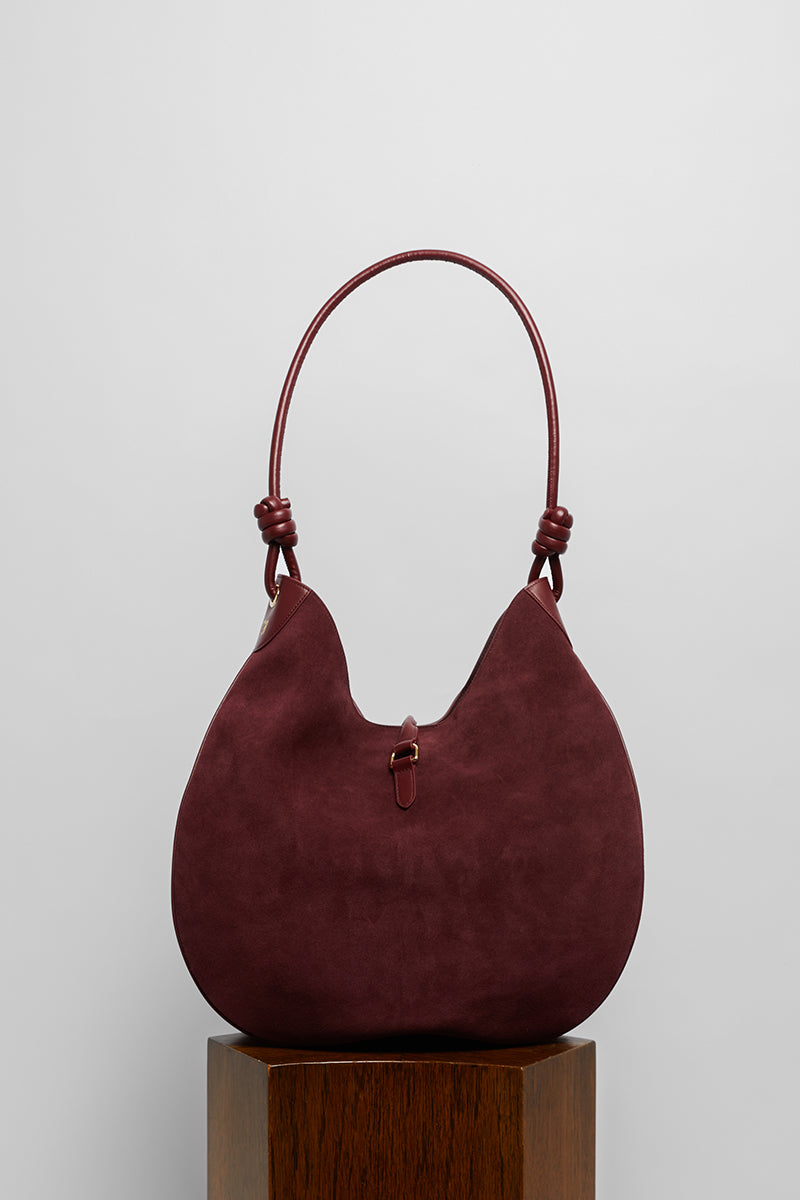 Maroon suede boho shoulder bag by Folklore The Label featuring a relaxed, stylish design with a shoulder strap and textured finish.
