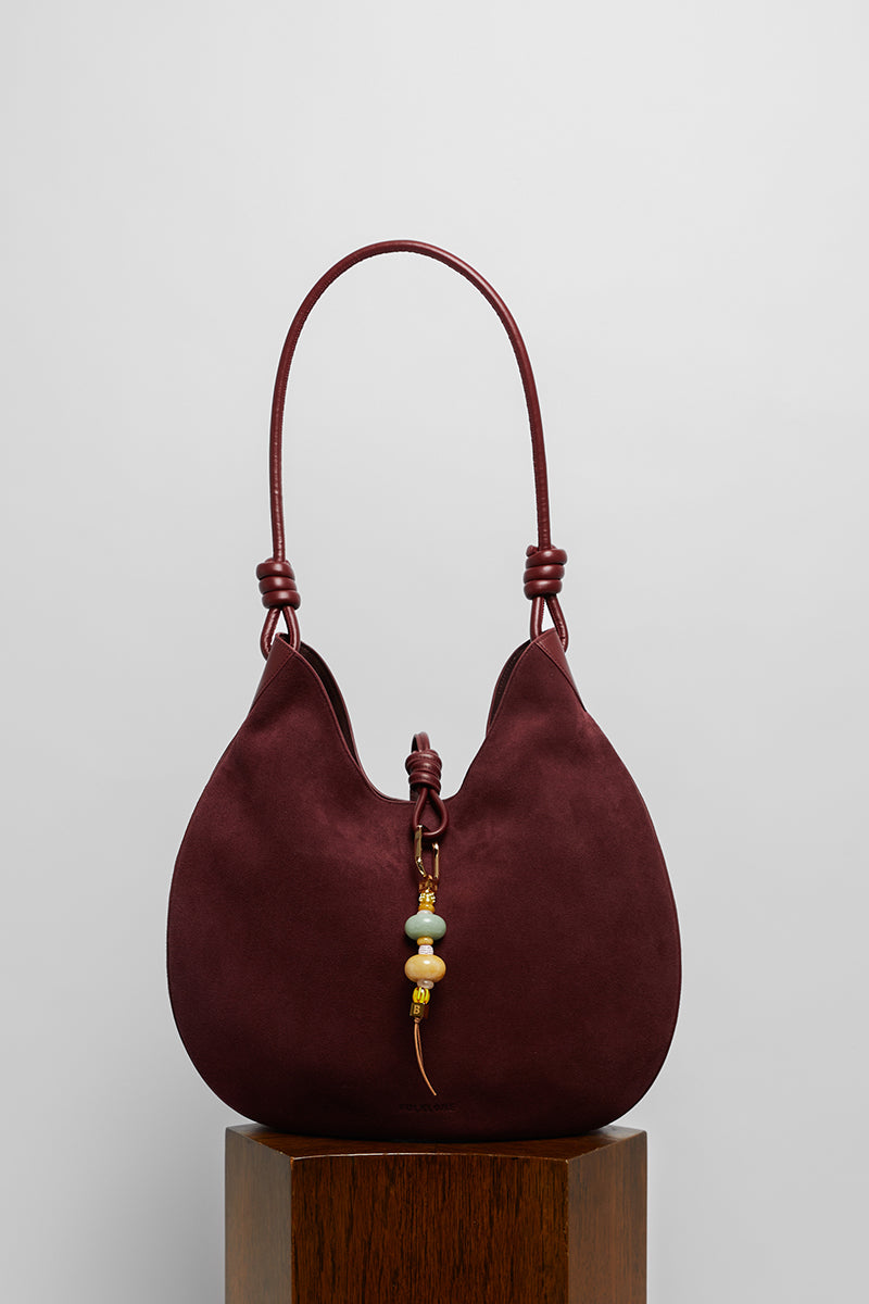 Maroon suede boho shoulder bag from Folklore The Label featuring a relaxed, stylish design and adjustable strap.