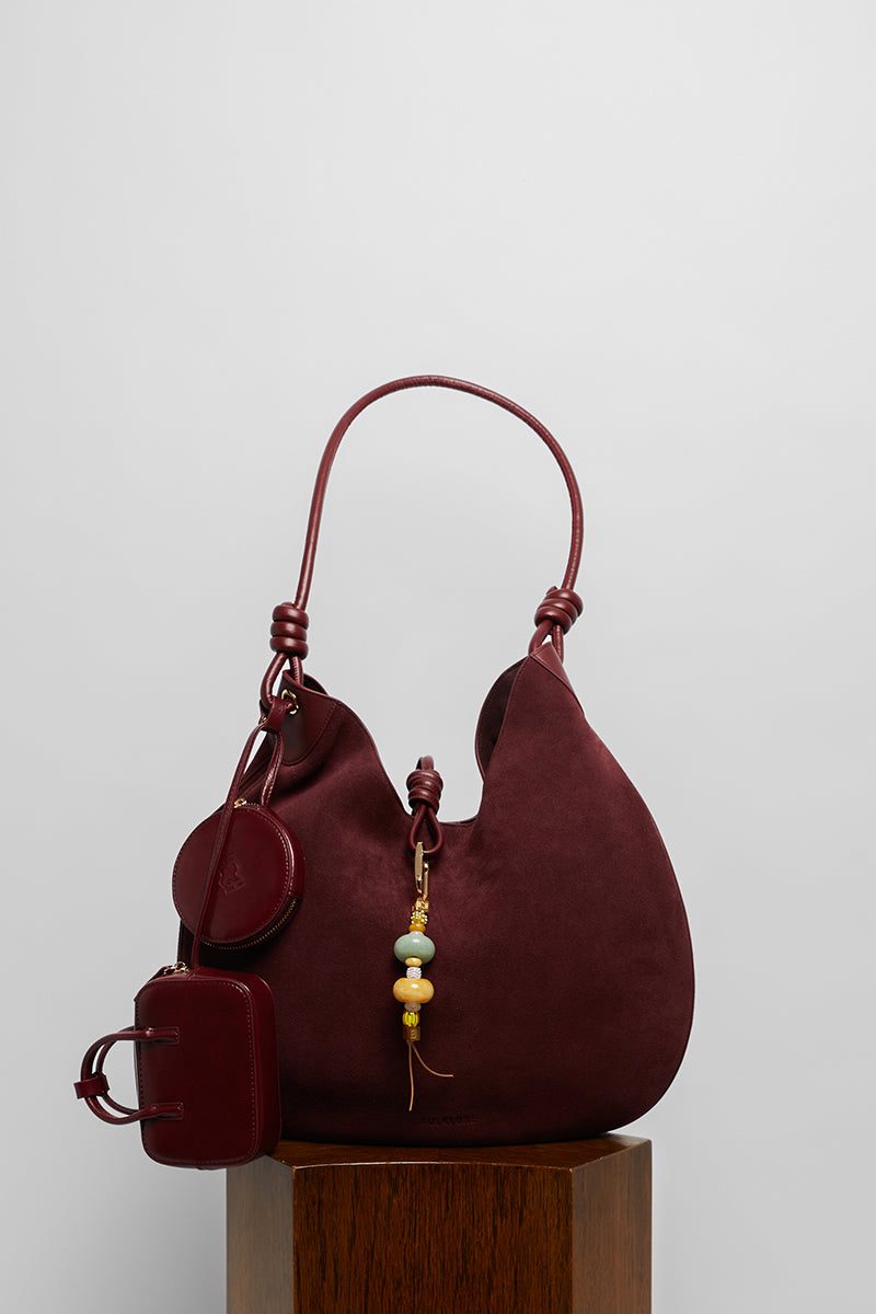 Maroon suede boho shoulder bag by Folklore The Label with relaxed, stylish design and adjustable strap.
