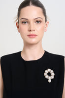 A white flow brooch by Aidan & Ice featuring a sleek, modern design on a neutral background.