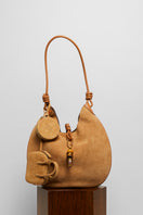 Beige suede boho shoulder bag by Folklore The Label, featuring a relaxed, stylish design with natural leather accents.