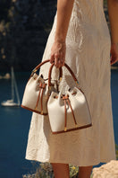 Saonara linen bucket top handle bag with a rounded shape and sturdy top handles, perfect for casual or elegant occasions.