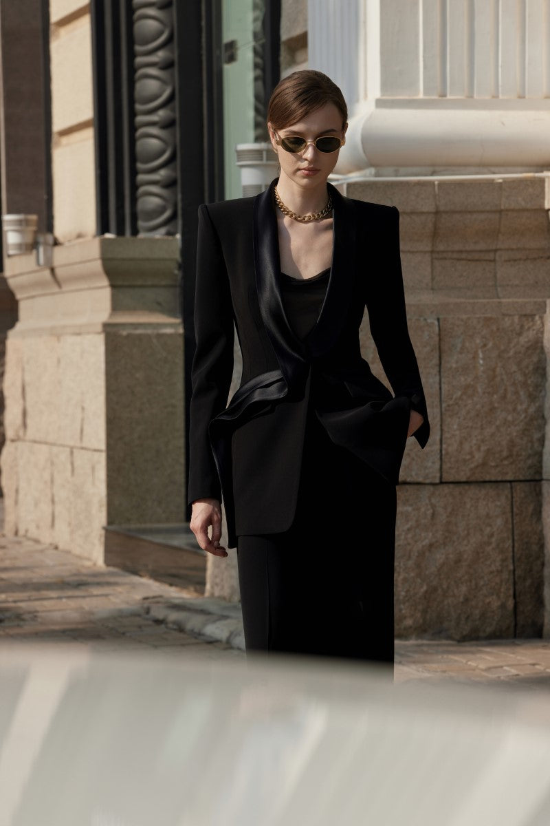 Black LEKIEU Darcey blazer jacket hanging on a wooden hanger, showcasing tailored fit and sleek style.