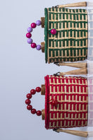 Green Catarina Mina Jirau basket bag with top handle, featuring woven design and spacious interior.
