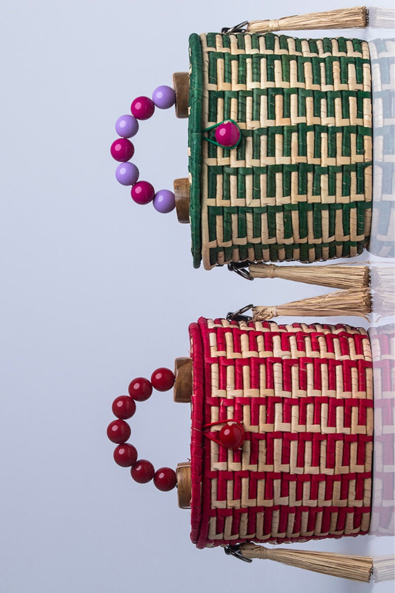 Green Catarina Mina Jirau basket bag with top handle, featuring woven design and spacious interior.