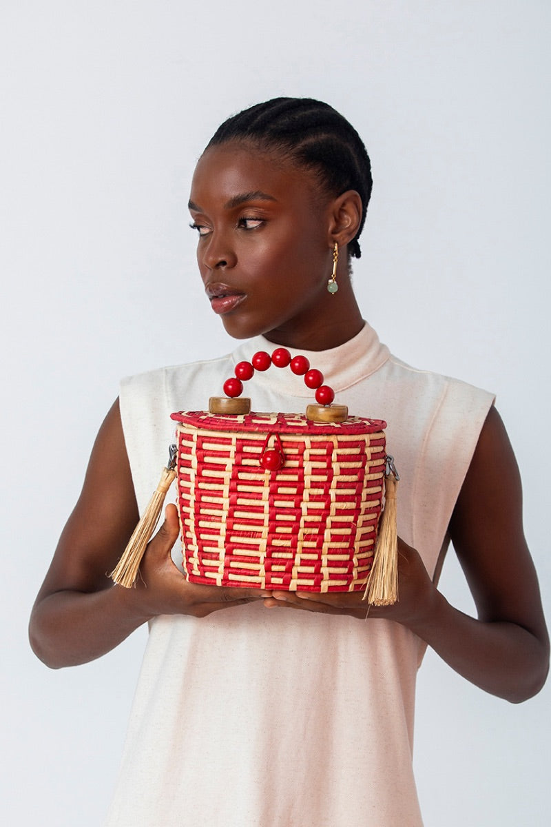 Red Catarina Mina Jirau basket bag with top handle, featuring woven design and stylish craftsmanship.