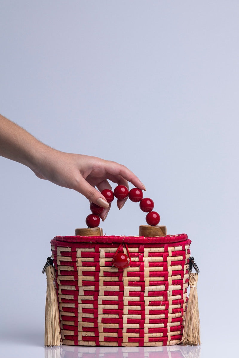 Red Catarina Mina Jirau basket top handle bag with woven design, featuring a sturdy handle and stylish craftsmanship.