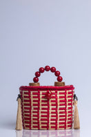 Red Catarina Mina Jirau basket top handle bag with woven design and sturdy handles, stylish and functional for everyday use.