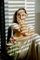 Green Catarina Mina Jirau basket bag with top handle, featuring woven design and spacious interior.