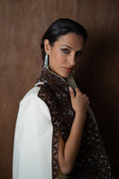 Nadya Shah Balthazar Cape jacket displayed on a hanger with detailed fabric texture and elegant design.
