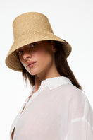 Beige bucket hat by LE SH KA, casual wide-brim hat made of soft beige fabric, displayed on a plain background.