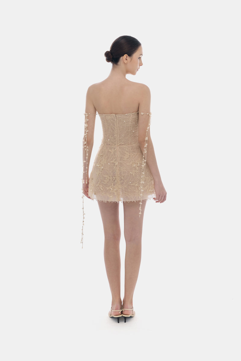 Beige floral string mini dress by Montsand, featuring lightweight fabric, adjustable straps, and a fitted silhouette.