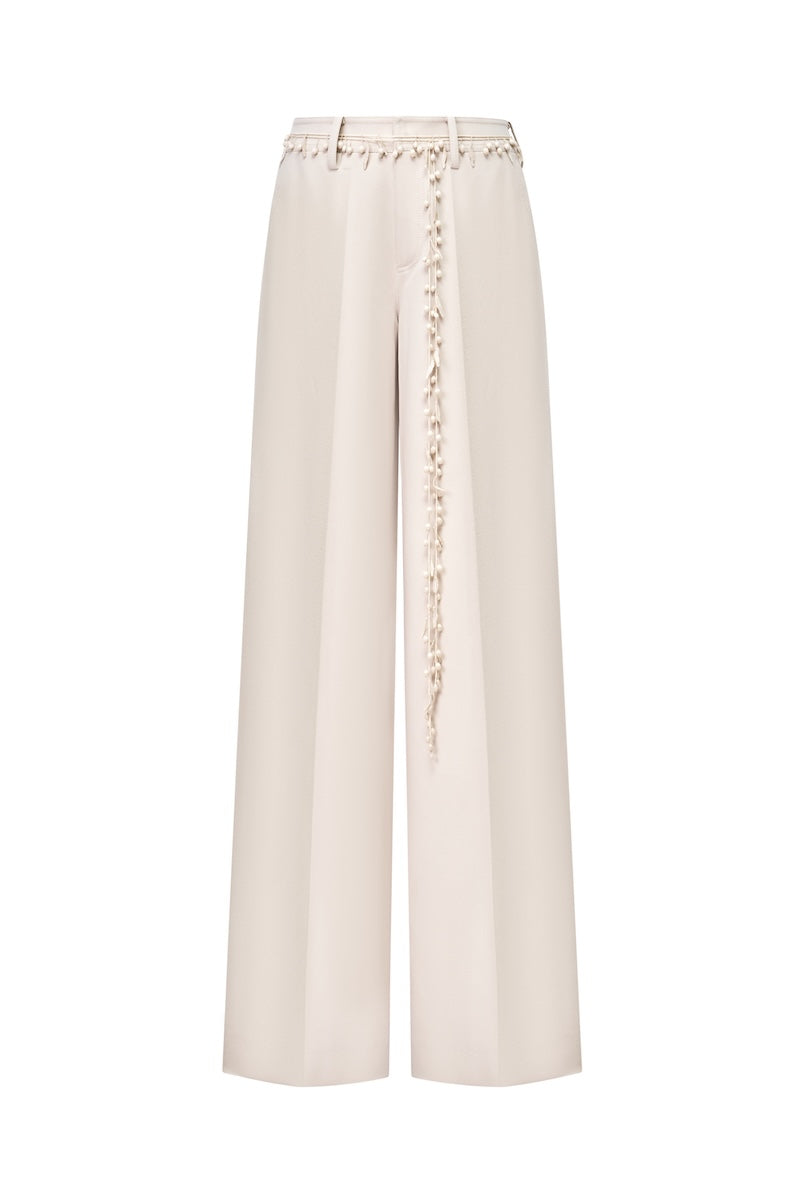 Beige Montsand pants featuring flower beaded embellishments on the trousers, showcasing stylish and elegant design.