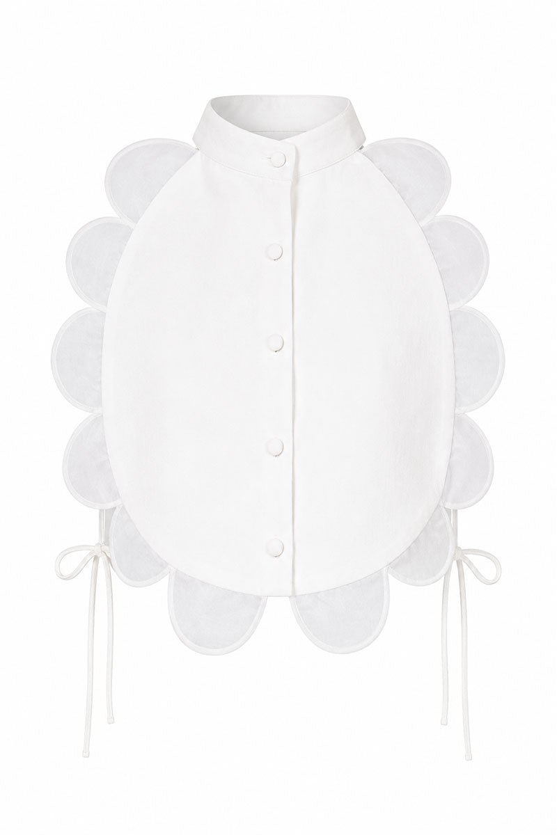 Ivory bib top from ANA + MARIA displayed on a ghost mannequin, featuring a stylish, sleeveless design with a rounded neckline.