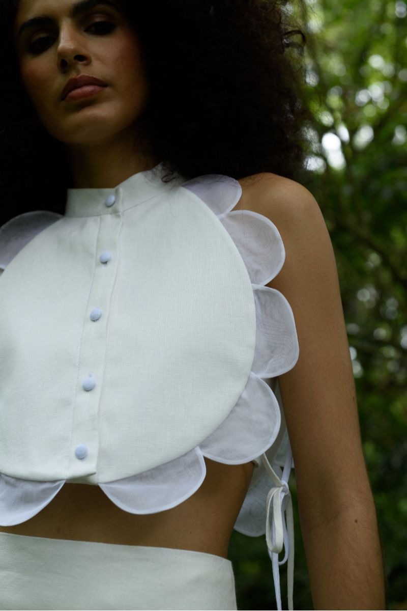 Ivory Bella Bib top by ANA + MARIA, featuring a stylish design, shown on a model in a fashion campaign photo.