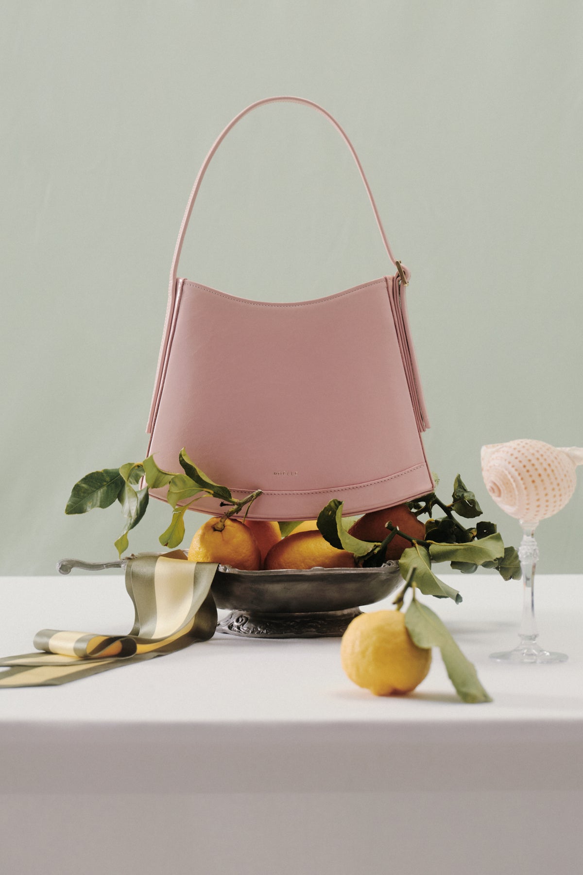 Pink POELLE Bell mini bag with top handle, stylish and compact accessory featuring a sleek design and vibrant color.