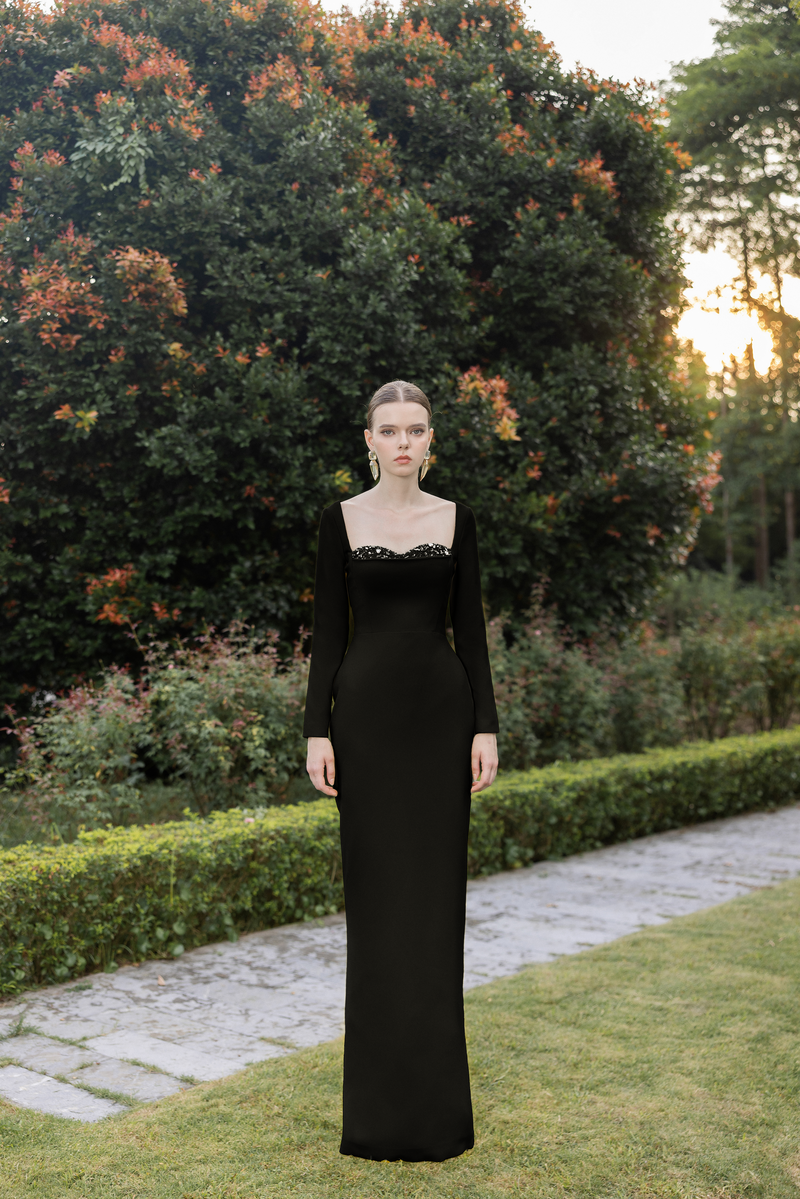 Black Elise Crepe Gown by 21Six displayed on a hanger with elegant flowing fabric and a fitted silhouette.