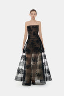 Black floral appliqué gown by Montsand featuring intricate embroidery and a flowing maxi design.