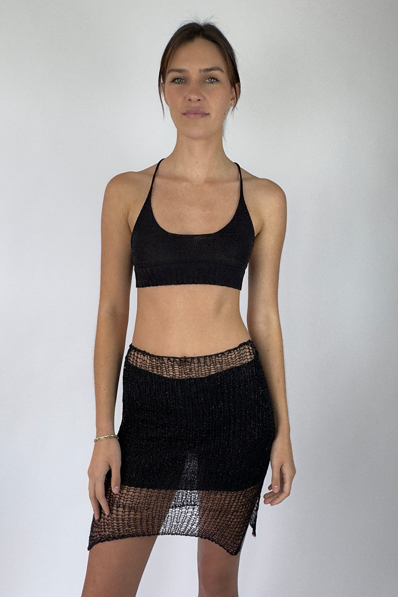 Black Midas mini skirt with slip by Natalia Fedner, shown from the front, featuring sleek black fabric and stylish design.