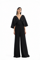 Black pleated SOMBRA PALMA jumpsuit by Maylé Vásquez, shown in an editorial portrait highlighting its stylish design and fit.