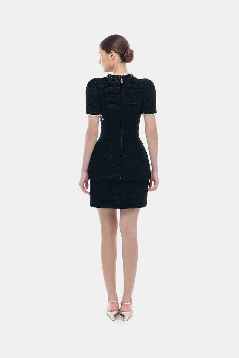 Black short sleeve tweed blazer by Montsand, featuring a tailored fit and classic design, shown paired with a matching tweed skirt.