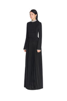 Black smocked maxi dress by Montsand shown from side view, featuring flowing fabric and fitted bodice for a stylish, comfortable look.