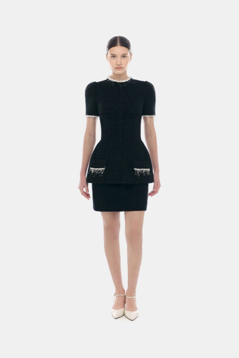 Black tweed mini skirt by Montsand, featuring classic textured fabric and a stylish fit, shown on a model.
