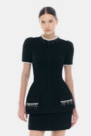 Black tweed mini skirt by Montsand, featuring a textured fabric and classic fit, shown on a neutral background.