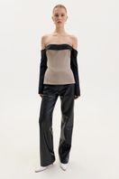 Black faux leather straight-leg pants by ELENAREVA, showing a close-up of the sleek, smooth material and tailored fit.