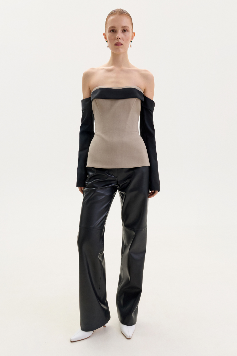 Black faux leather straight-leg pants by ELENAREVA, showing a close-up of the sleek, smooth material and tailored fit.