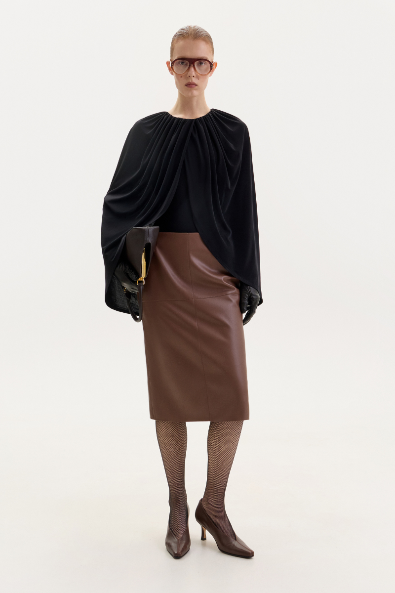 Black jersey cape bodysuit by ELENAREVA, featuring a sleek, fitted design with cape-style shoulders and long sleeves.